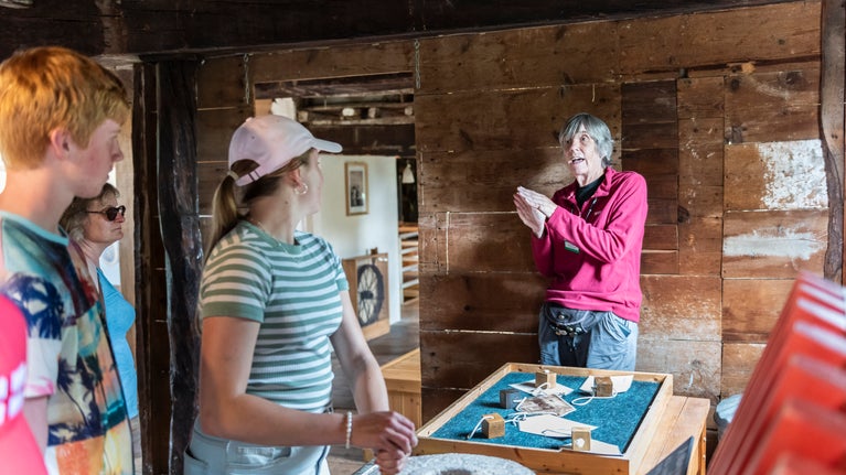 Visitors engaging with Volunteer guide inside Houghton Mill